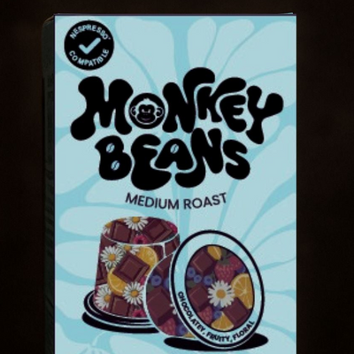 Box of Monkey Beans coffee pods with a blue background and colorful coffee pod illustration.